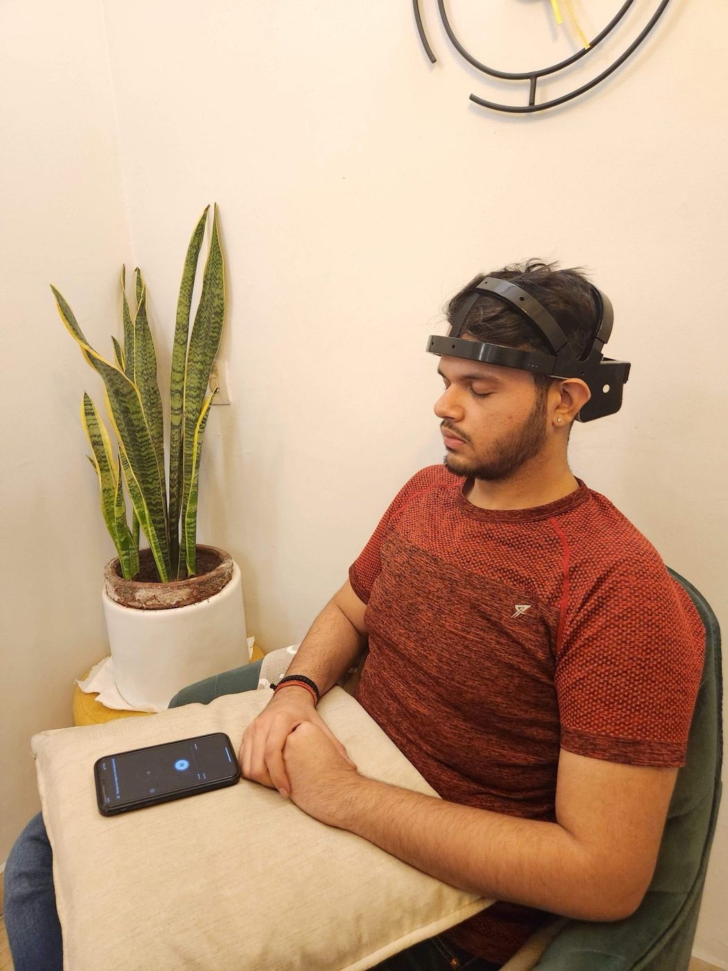 A client seated with eyes closed wearing a BrainTap headset during a guided session