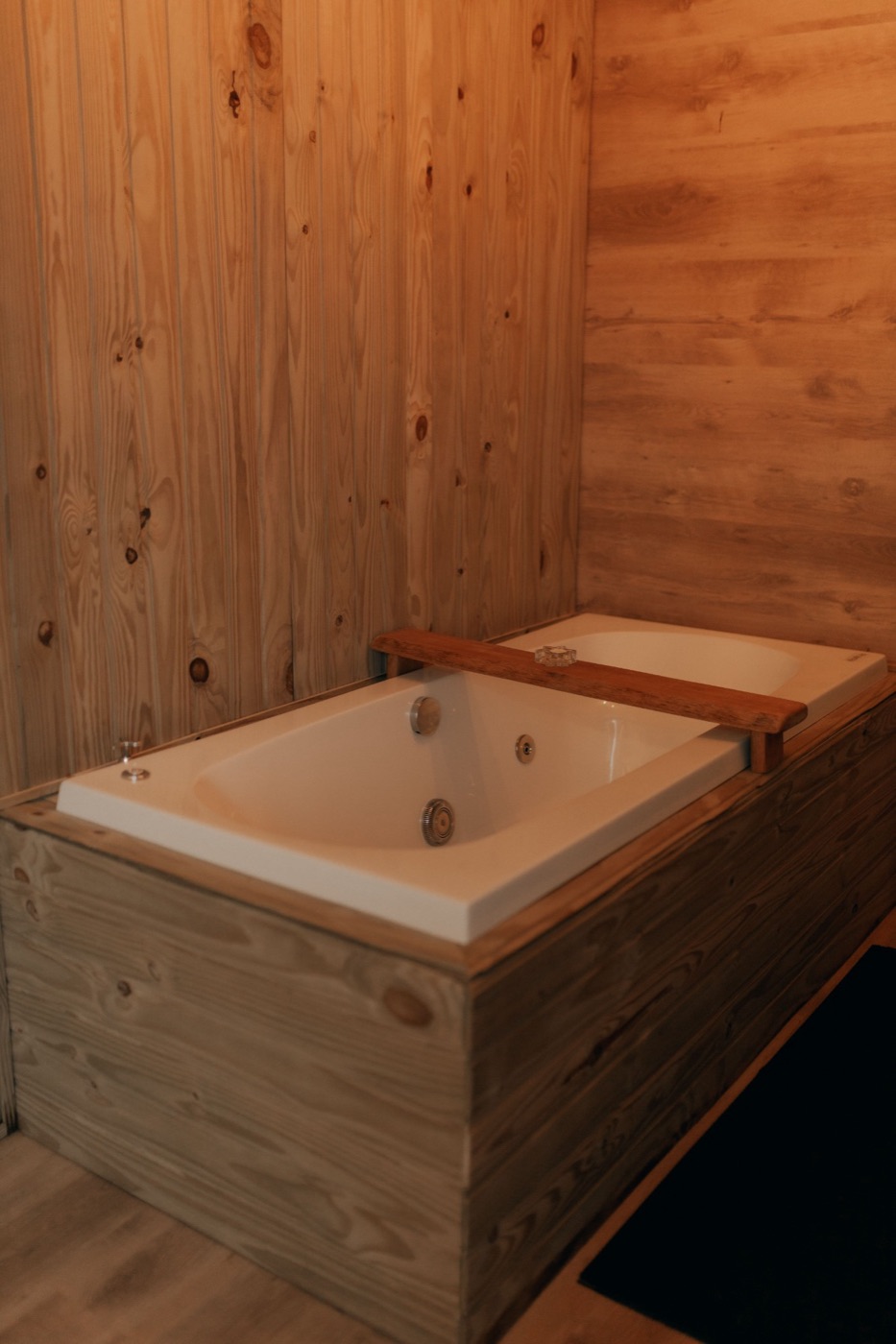 A cold plunge tub set into a wood-paneled room