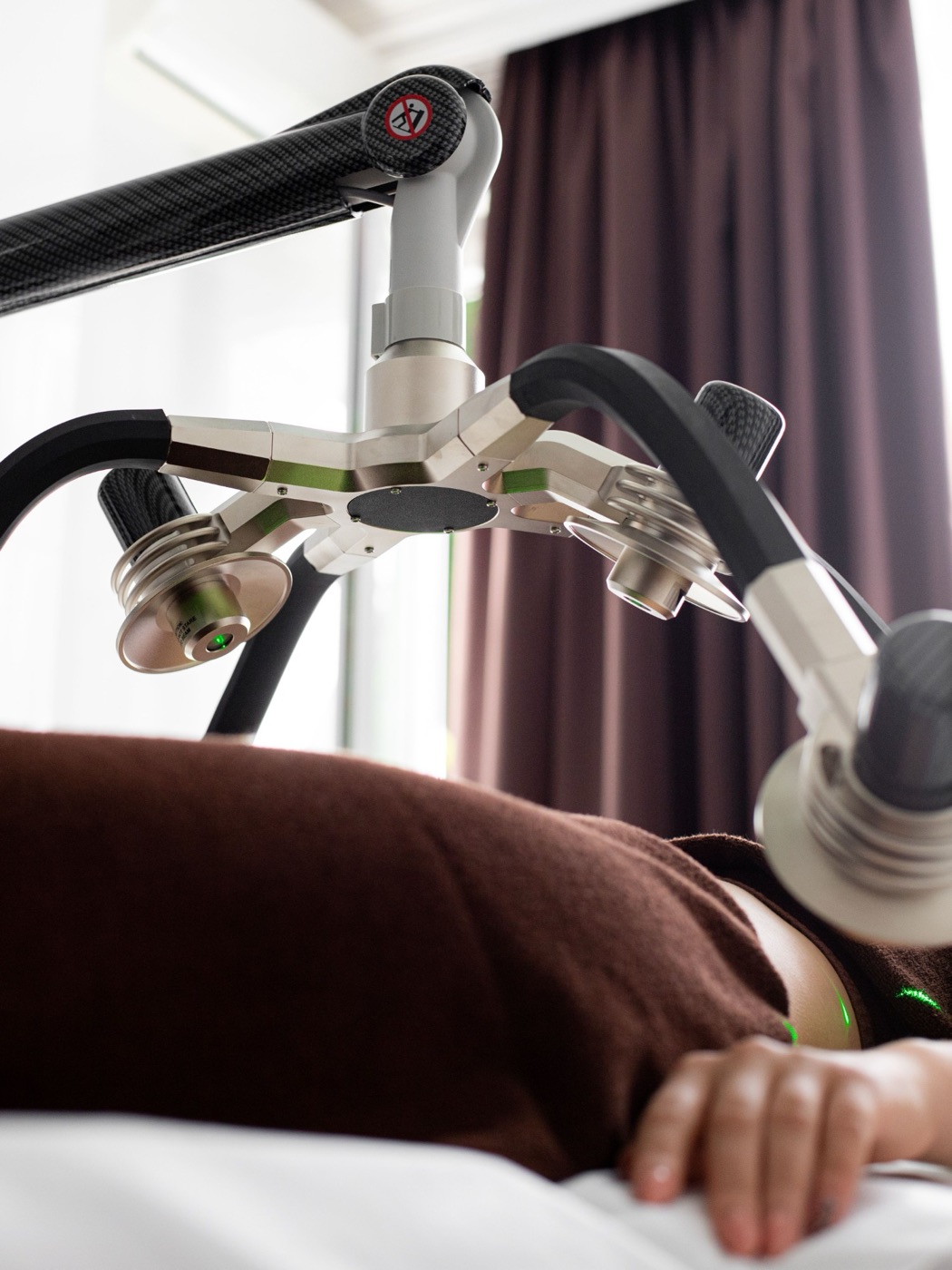 A PEMF therapy applicator positioned over a client lying on a treatment table