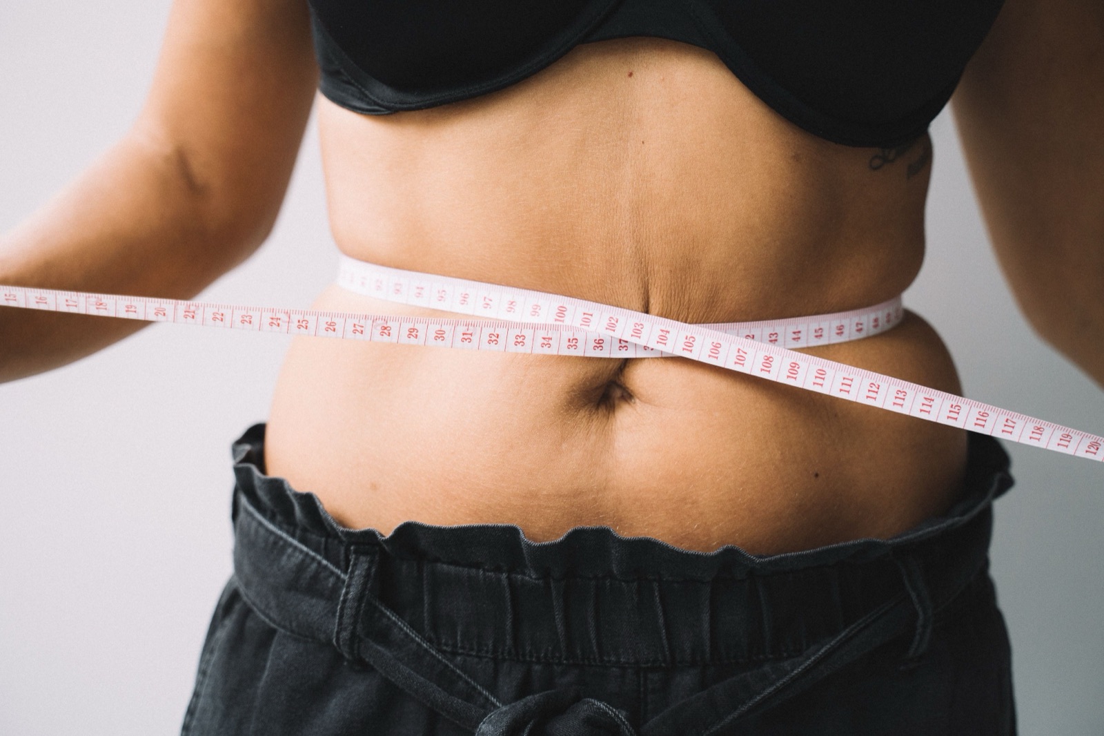 A tape measure around a client's waist during a weight management consultation